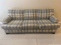 Full front view of the three-seater couch showing plaid upholstery and overall structure.