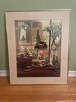 Framed print showing the full view of the cafe scene including bottles, flowers, fruit basket, and poster outside the window.