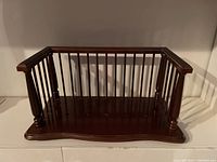 Front view of the mahogany tabletop book shelf showing vertical slats on three sides with a polished finish