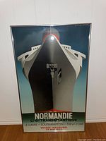 Front view of the framed Normandie Ocean Liner print showing the ship bow and voyage details.