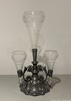 Front view of epergne showing metal base and five glass vases