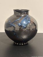 Image of the vase showing the left side abstract blue pattern on metallic glaze.