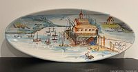 Front view of the large oval platter showing the hand painted harbor scene with boats and buildings on water.