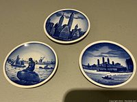 All three miniature pin dishes in blue and white flow blue pattern showing New York 1939 scenes