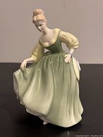 Front left-side angled view of Royal Doulton Fair Lady figurine showcasing detailed dress and face.