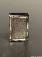 Front view of sterling silver matchbox holder showing decorative beaded border and oxidized panel.