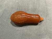 Top angled view showing amber color and carved leaf detail on snuff bottle