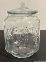 Front view of clear glass Planters jar showing embossed text and Mr. Peanut figures.