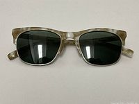Front view of Warby Parker Ellison sunglasses with light grey tortoiseshell frames and dark lenses.