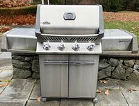 Front view of grill showing lid, control panel, cabinet and casters