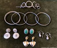 Full collection showing silver-tone hair stick with circular design, four bangles including Sterling silver twisted bangle, three pairs of pierced silver-tone earrings, and malachite Sterling clip-on earrings.