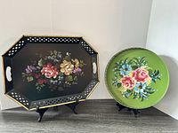 Photo of two trays on stands, octagonal black floral tray and round green floral tray