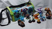 All 13 Skylanders figures shown with the matching themed carry bag, depicting the various characters and bag in full view.