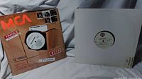 Two 12-inch vinyl records in cardboard and white sleeves, MCA Records branding visible on one sleeve.