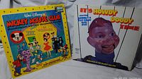 Both vintage records shown side-by-side on fabric background. Covers include Mickey Mouse Club and Howdy Doody Time.