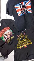 Photo showing The Who, Heart, and Def Leppard band T-shirts with visible logos and graphics.