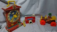 Photo showing all three toys together: music box clock, changeable picture disc camera, and jalopy clown car.