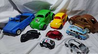 Full view of all VW-themed items including green hot rod, yellow bug, wooden carved bug, blue Flower Power van, police bug, red and black bugs, and silver and blue VW mice.