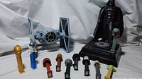 Photo showing Darth Vader piggy bank, handheld X-Wing fighter, and a lineup of Star Wars PEZ dispensers