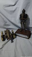 View of two collectible radios: one shaped like a Civil War cannon, the other a knight statue on a base with plaque.