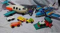 Full set showing Fisher-Price Jumbo Jet, Tonka vehicles, and Lego Spider-Man figure on gray toy jet
