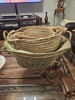Three stacked wicker laundry baskets, largest with light green liner inside.