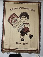 Full view of the large tapestry showing the child illustration, Campbell's Soup can, anniversary text, and border with fringe.