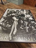 Full view of the black and white framed poster featuring Bad Company band members on a motorcycle with a woman sitting prominently, band name and credits visible.