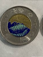 2011 Glow in the Dark Toonie showing northern lights design with glow elements