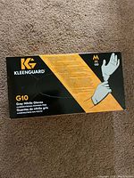 Photo of front of box showing brand KleenGuard, product G10, grey nitrile gloves, medium size, 150 gloves, powder-free.