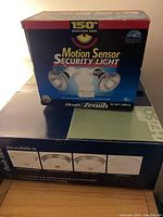 Box front of Heath Zenith Motion Sensor Security Light showing 150° detection zone and dual metal halide bulbs.