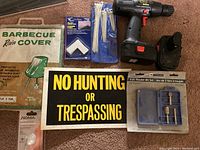 Full lot arranged on carpet showing various tools, hardware, sign, and BBQ cover