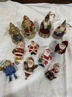 Top view of all 11 Santa ornaments laid out on white cloth