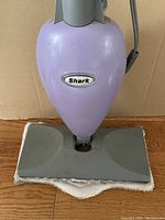 Front view of purple Shark steam cleaner with cloth attached to the cleaning head.