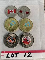 Six Canadian coins shown on white background including loonies, toonies, and quarters with colored designs.