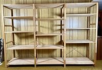 Front overview of all three connected IVAR shelving sections against wood panel wall