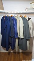 Full view of six London Fog jackets and coats hanging on a rack, showing various styles and colors.