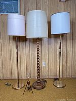 Four lamps arranged against wood-paneled wall, floor overview