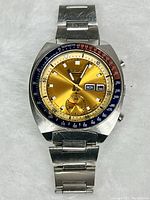 Front view of watch on white background showing gold dial and bi-color bezel