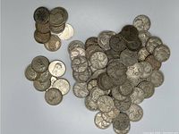 Pile of Canadian silver quarters spread on white background