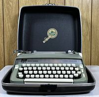 Front view of Smith Corona Super Sterling typewriter in case with keys visible, showing overall condition and color.