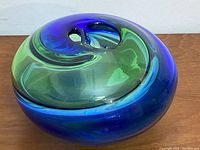 Top-down view of disk-shaped vase showing central opening and color swirl