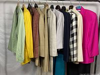 Full rack view of assorted blazers and skirts hung on a clothing rack