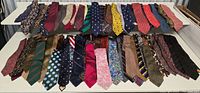 Full lot view showing two rows of assorted neckties laid flat
