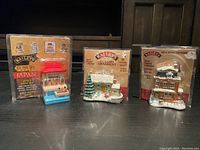 Photo showing three Baileys Christmas ornaments in original packaging on a black surface.