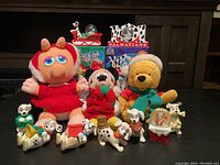 Disney Christmas lot showing plush toys of Miss Piggy, Mickey Mouse, Winnie the Pooh, and multiple Dalmatian figurines along with Christmas themed decorations.