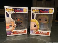Front view of boxed Funko Pop figures Geppetto and Blue Fairy from Disney's Pinocchio, showing full packaging and figure visibility.