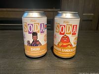 Two Funko Soda figure cans side by side featuring Shuri and George Sanderson characters.