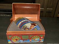 Box containing 10 Toy Story discs arranged in foam insert, box decorated as Toy Story wagon.