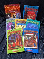 Seven Goosebumps books arranged and spread showing covers and titles